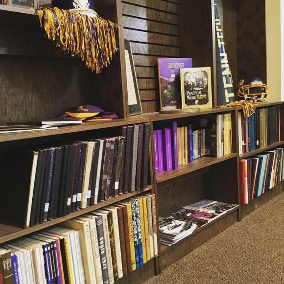 Yearbooks and Tech items on a bookshelf.