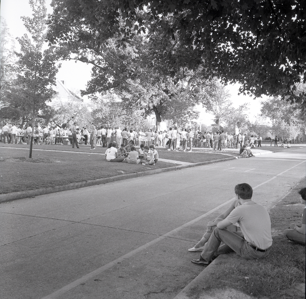 Black and white photo of people gathered on the Quad for an event.