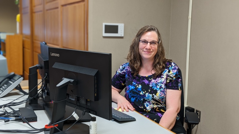 Jenny Huffman sitting at a desk in the archives