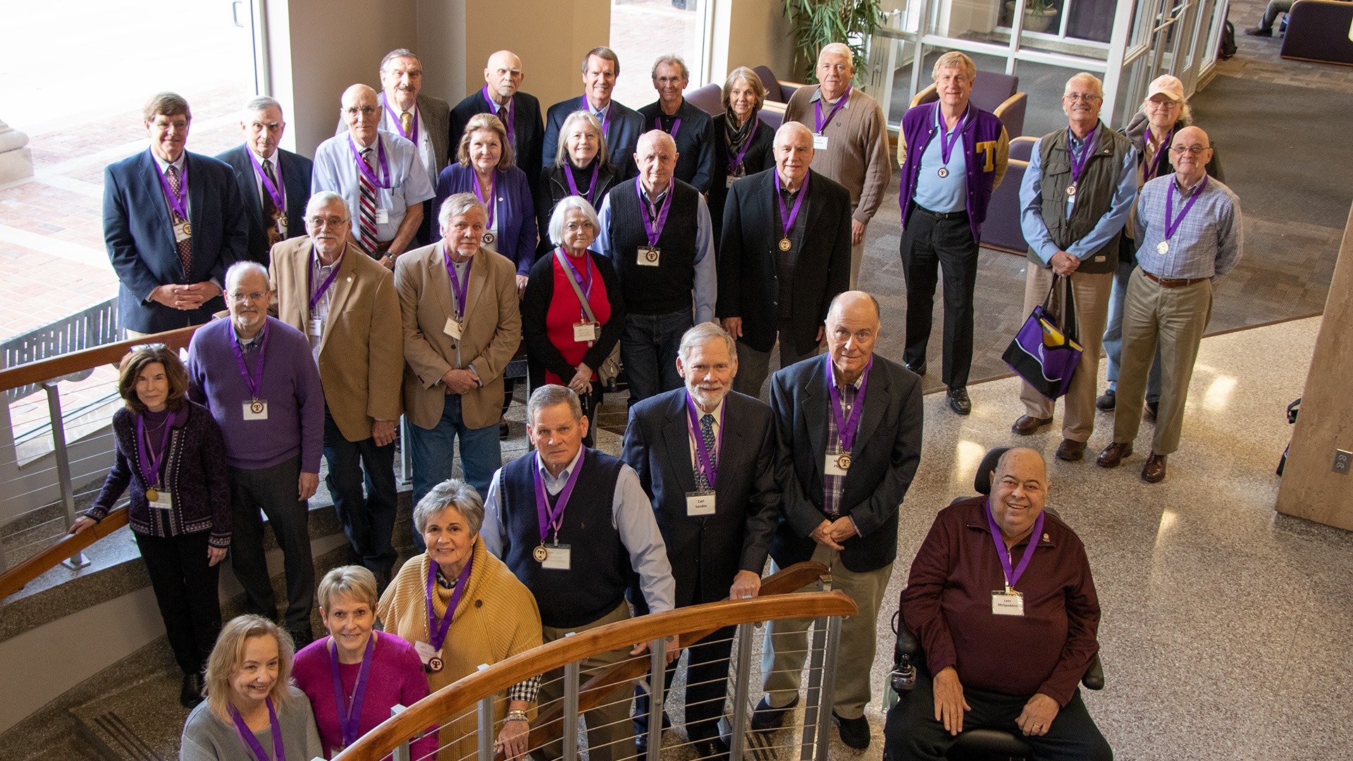 A group photo of attendees of the Golden Grad reunion. They are standing on the stairs going into the basement of the University Center.