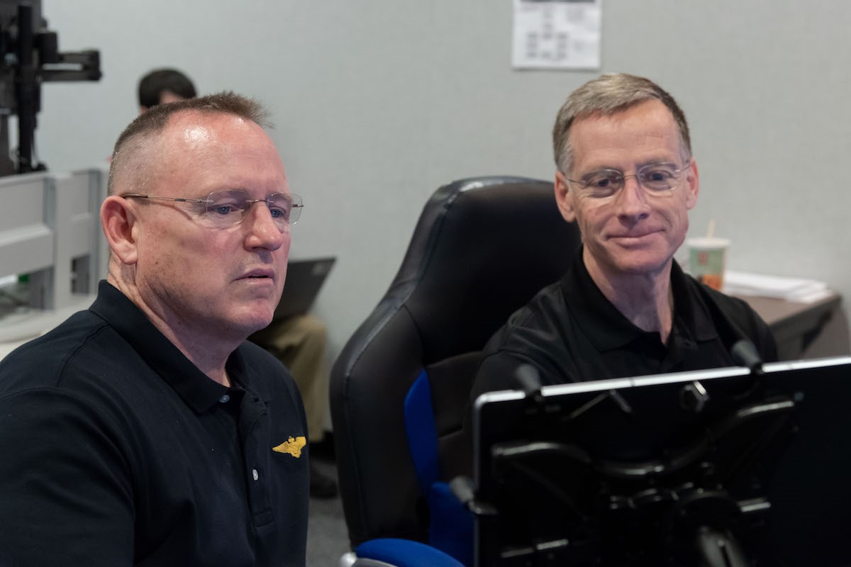 Photo of Barry Wimore looking at a computer monitor next to another gentleman.