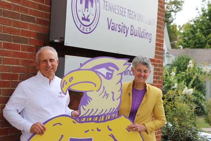 A photo of Ottis Phillips and Dianne Murphy smiling behind a cutout of Tommy Tech. 