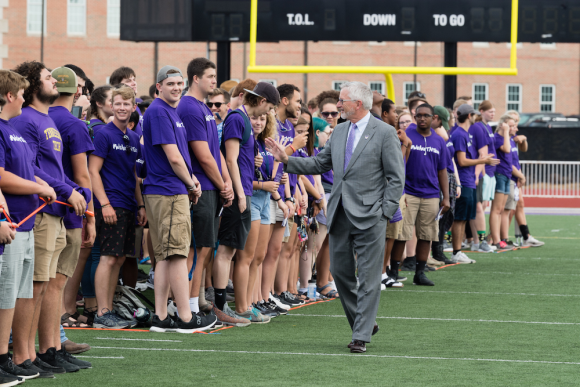 Dr. Phil Oldham waving at new students during running of the freshmen event