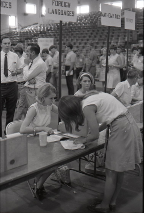 photo circa 1969 - female student registering for a foreign language at a table set up on the floor of memorial gym