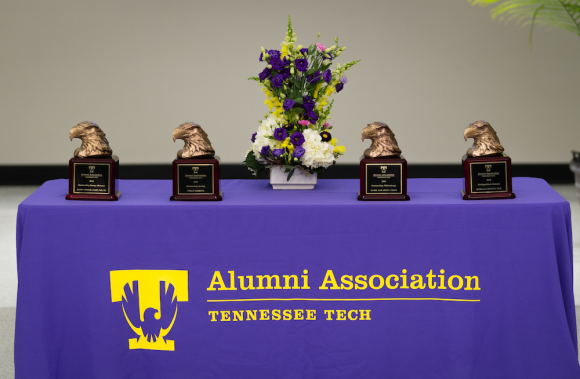 Bronze eagle head alumni awards sit on a table with a cloth reading "Alumni Association, Tennessee Tech"