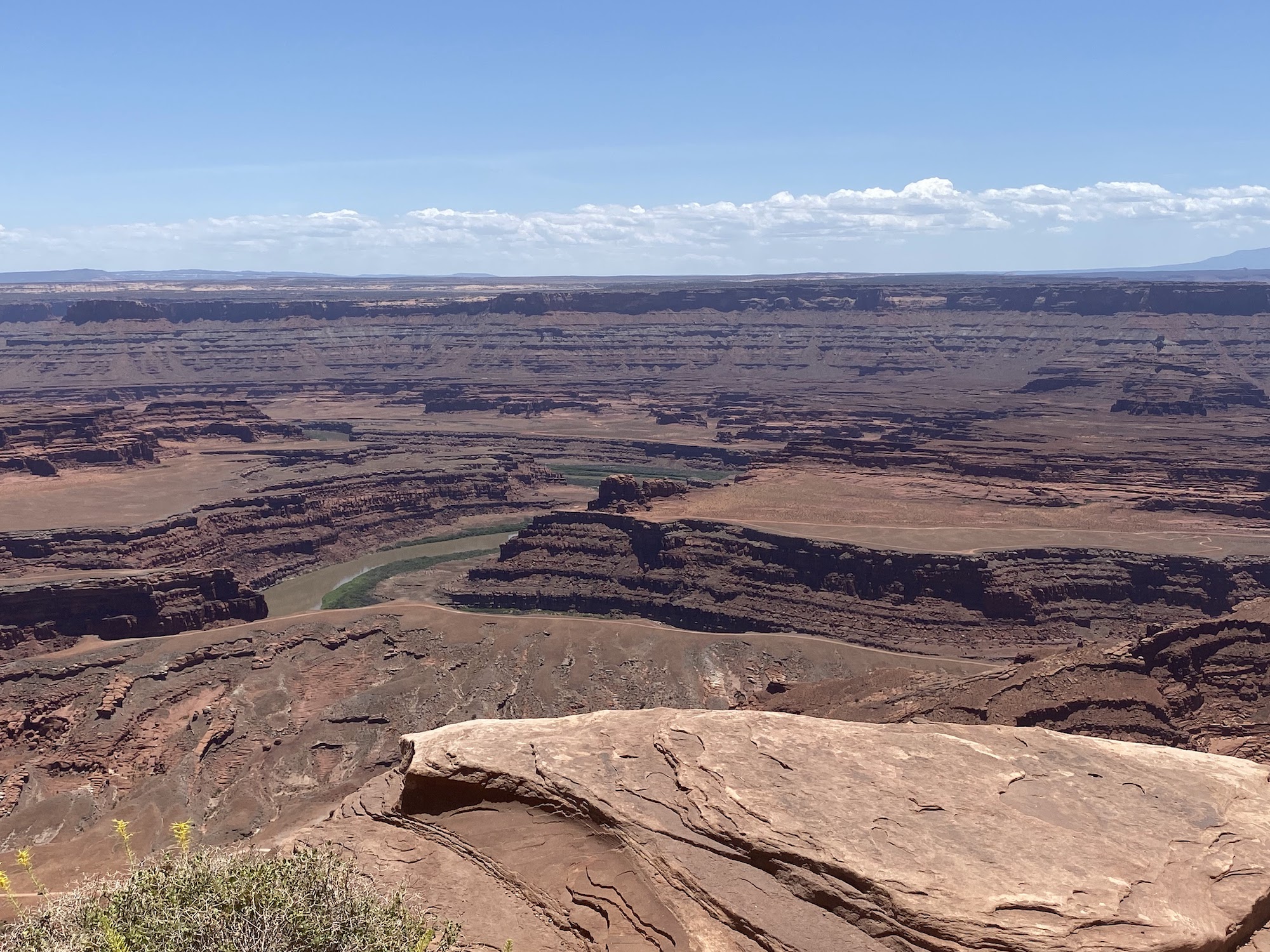 A river at the bottom of a deep canyon in brown layered rock.