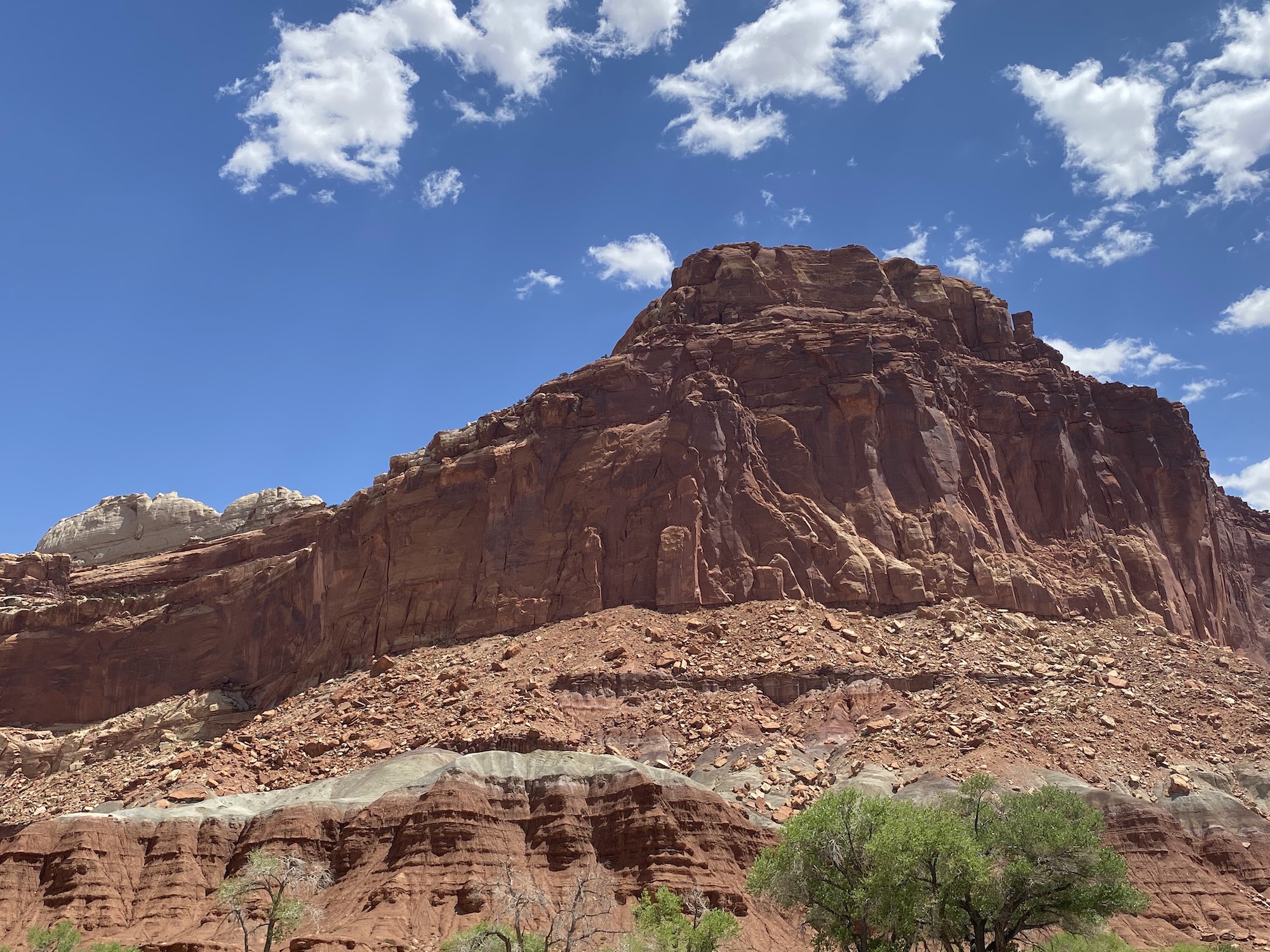 red sandstone juts up into the a blue cloud-filled sky