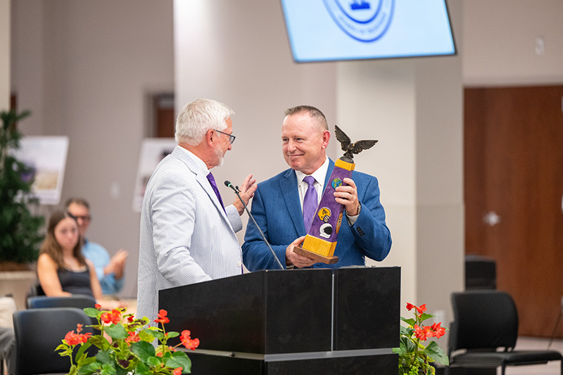 President Phil Oldham handing Barry Wilmore the Order of the Eagle award.