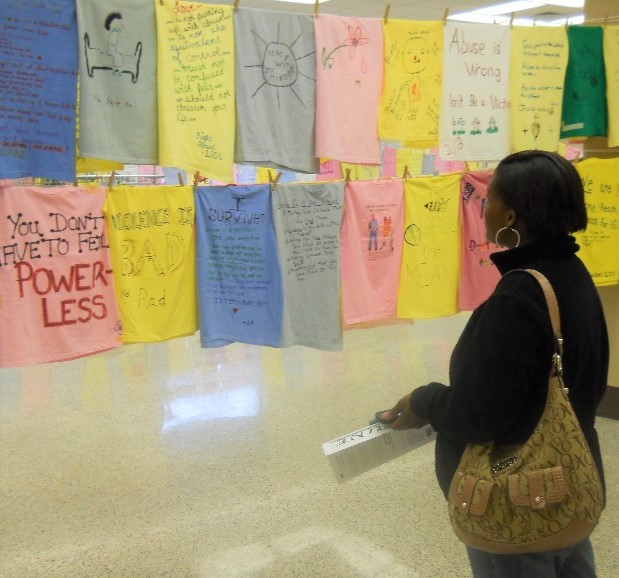 A woman standing in front of the clothesline, taking in the witness statements.